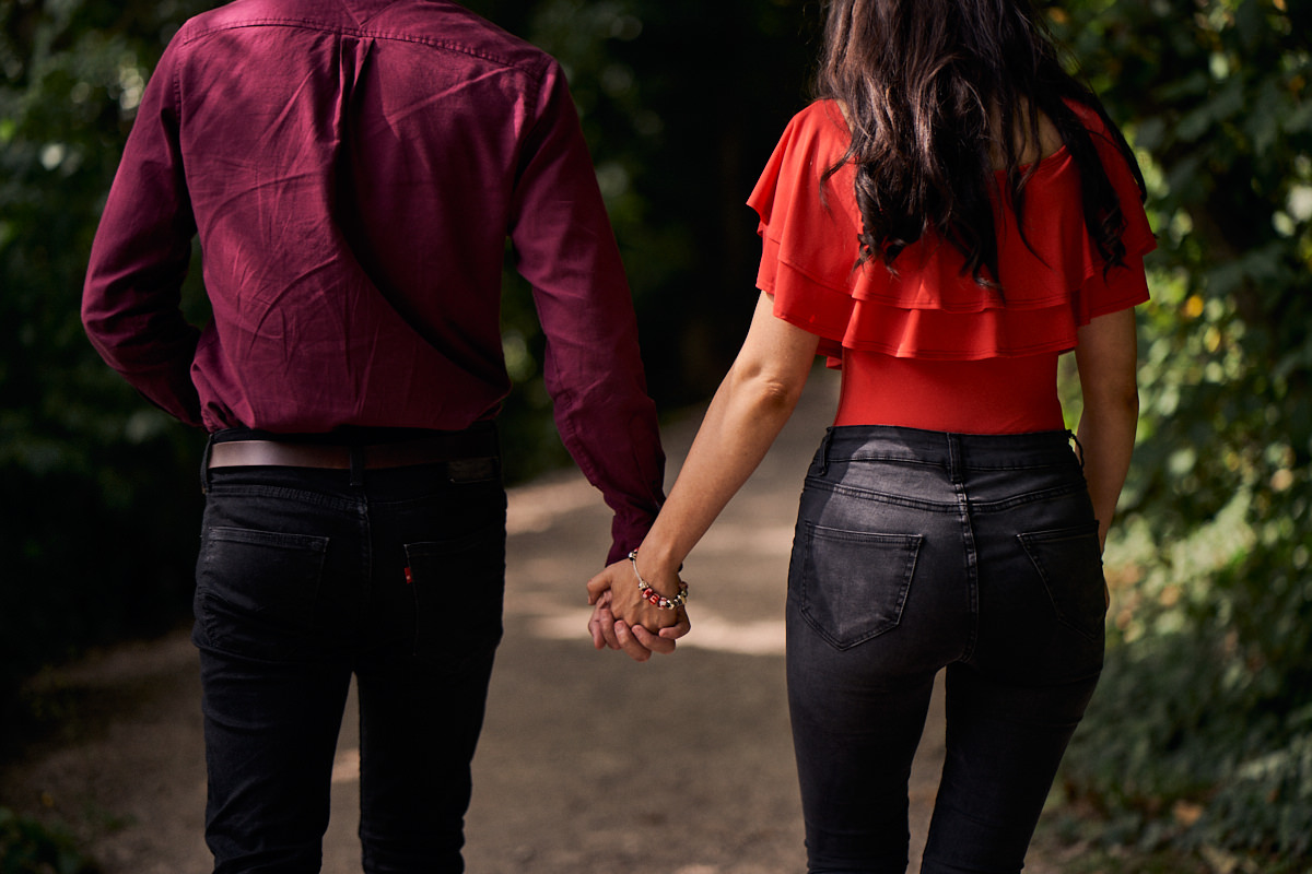 couple holding hands going for a walk through the woods