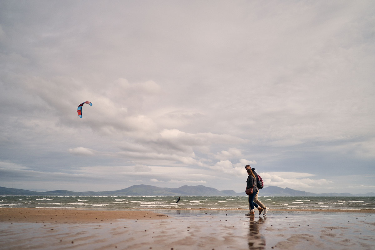 couple walking along Newbourgh Beach, Anglesey