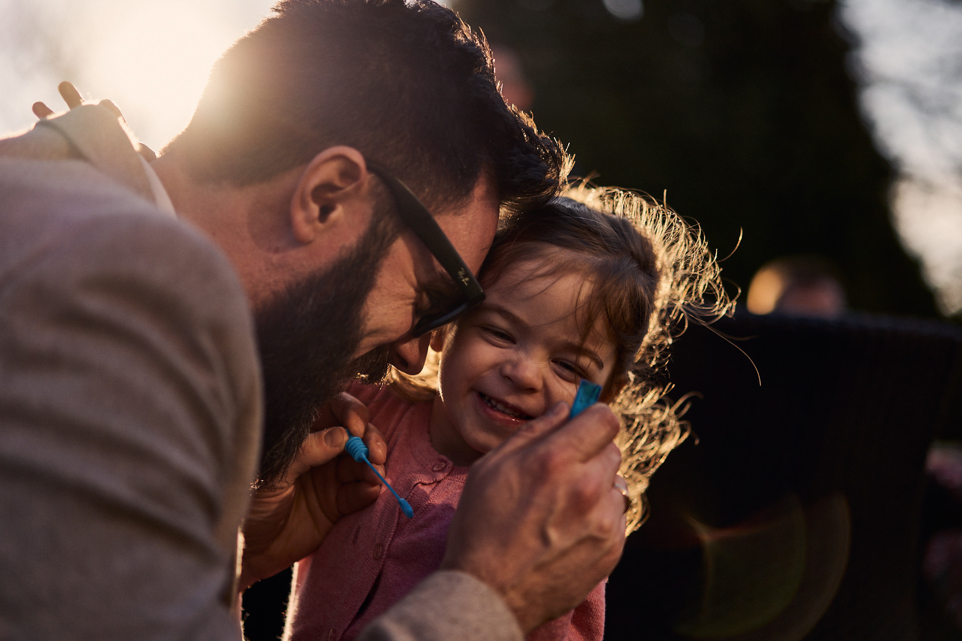 dad playing bubbles with twin daughter