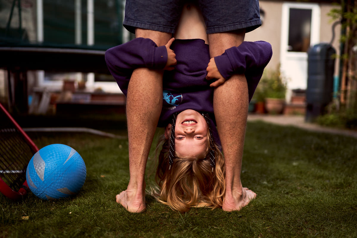 dad hanging daughter upside down by her feet