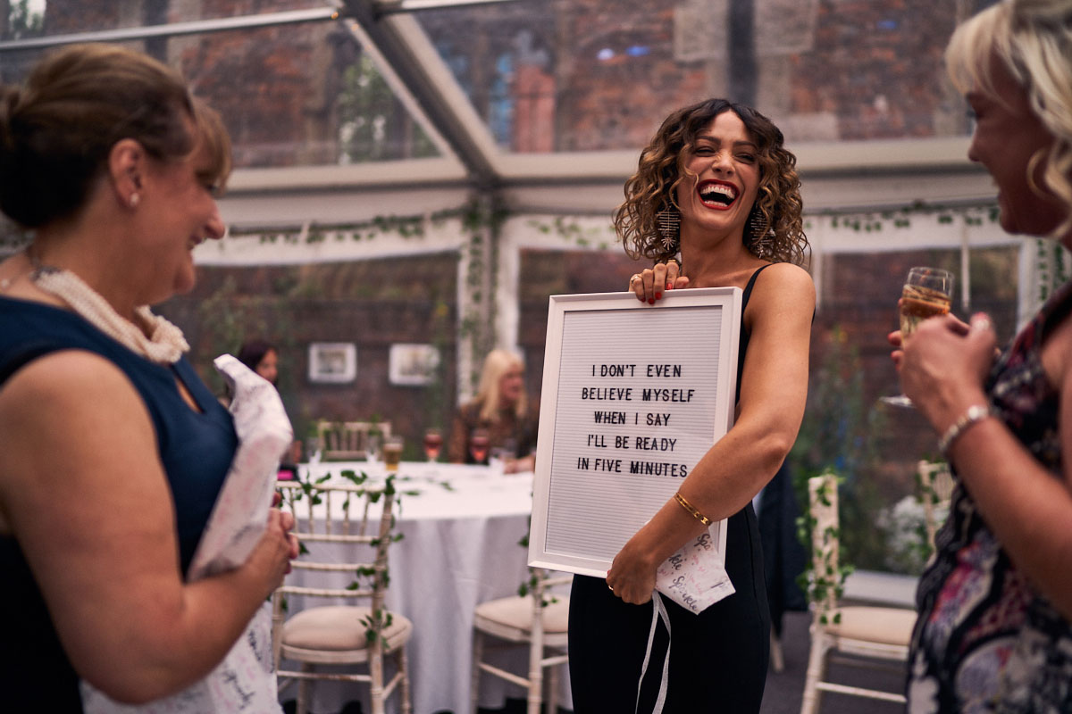 woman opening birthday present and laughing