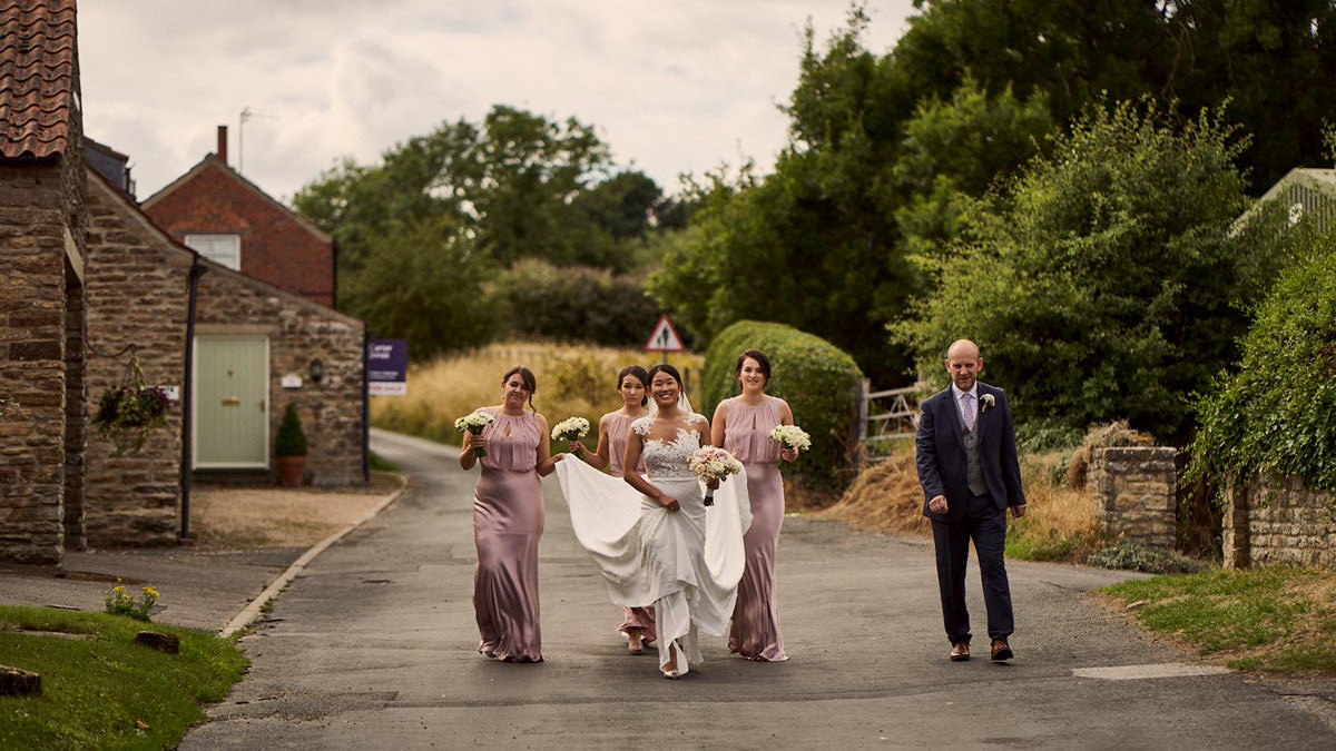 Bridal party walking to the church in Terrington, yorkshire