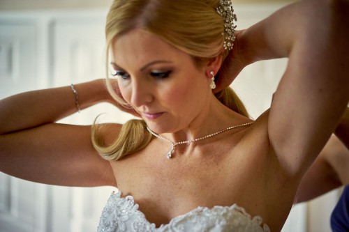 bride putting necklace on