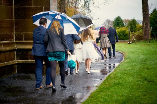 wedding guests leaving the church in the rain