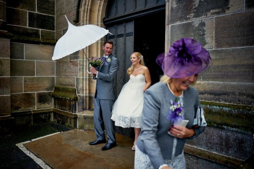 bride and groom leaving church in the rain