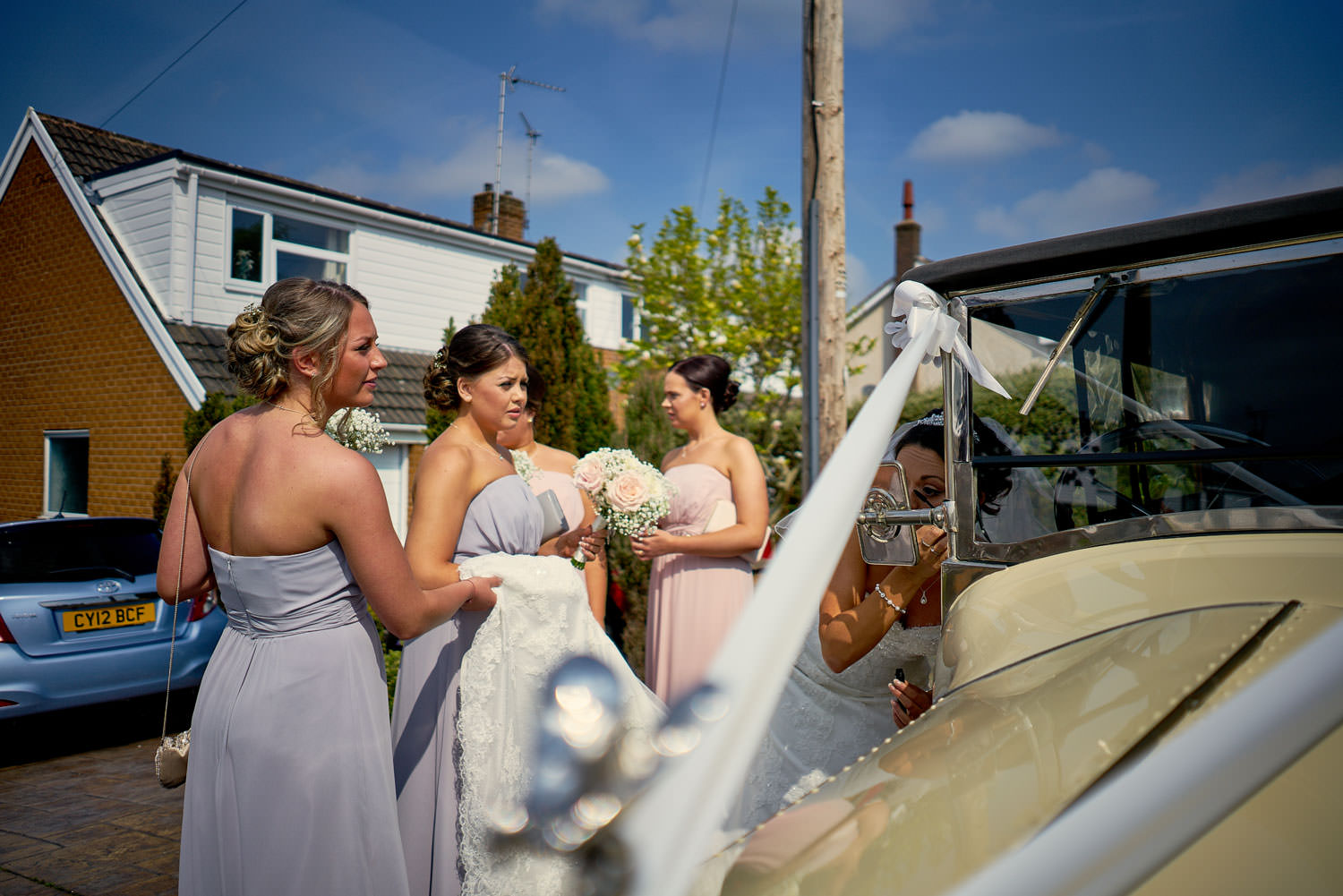 bride doing her makeup in vintage car mirror