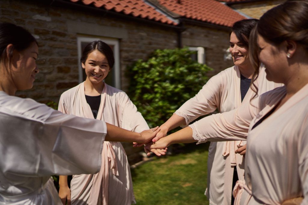 Bride & Bridesmaids having a team meeting outside in the sunshine