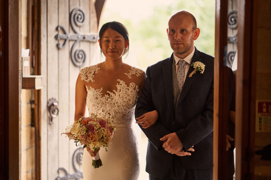 Bride & father of the bride walking into the church