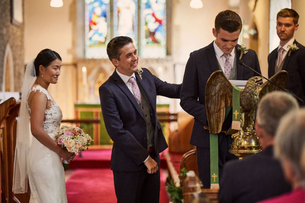 Groom giving Best Man a reassuring hug while he does his reading
