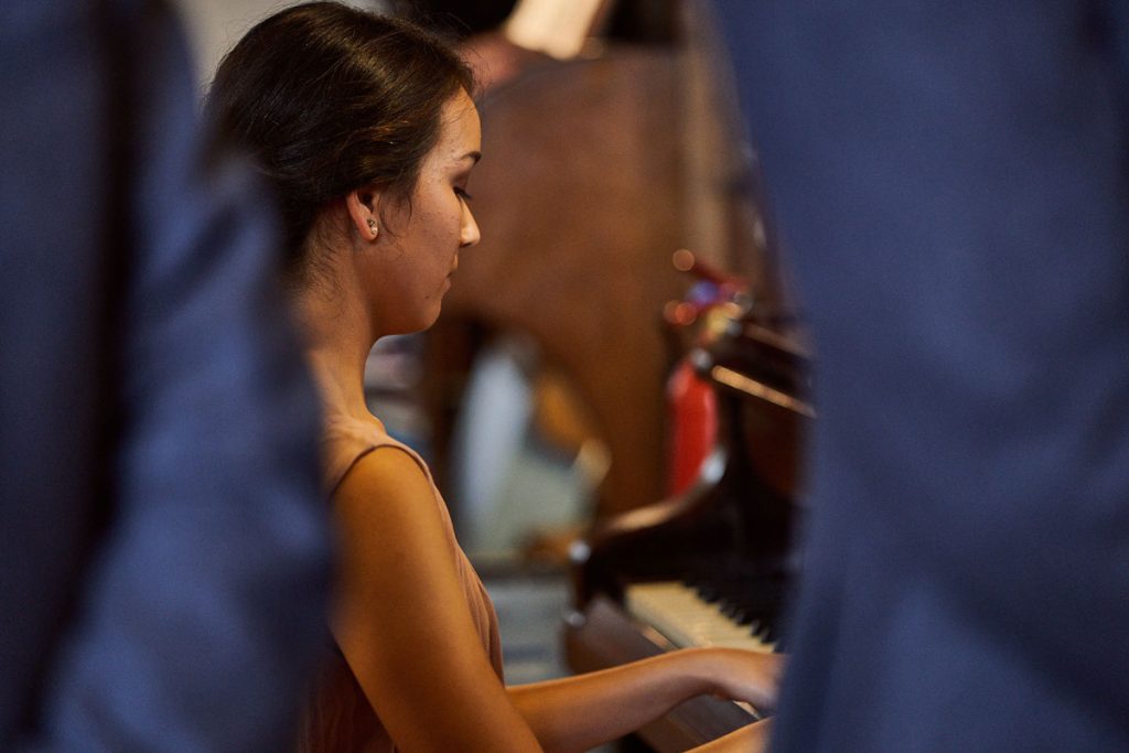 Bridesmaid playing piano during wedding service