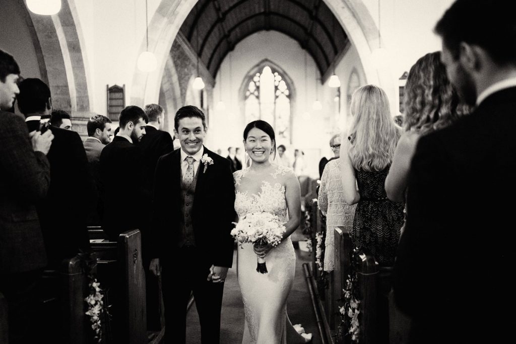 Bride & Groom smiling as they leave the church just after getting married