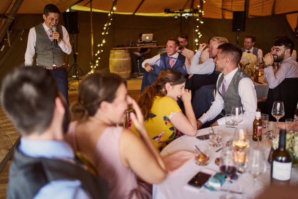 wedding guest laughing hard at grooms speech