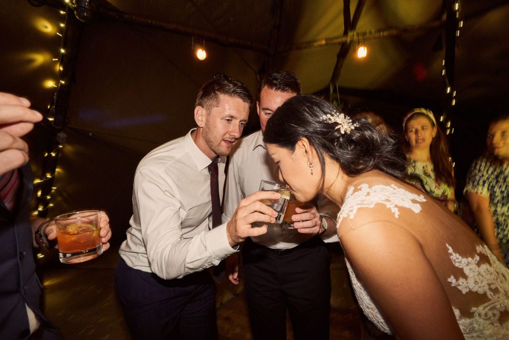 Bride drinking from wedding guest glass