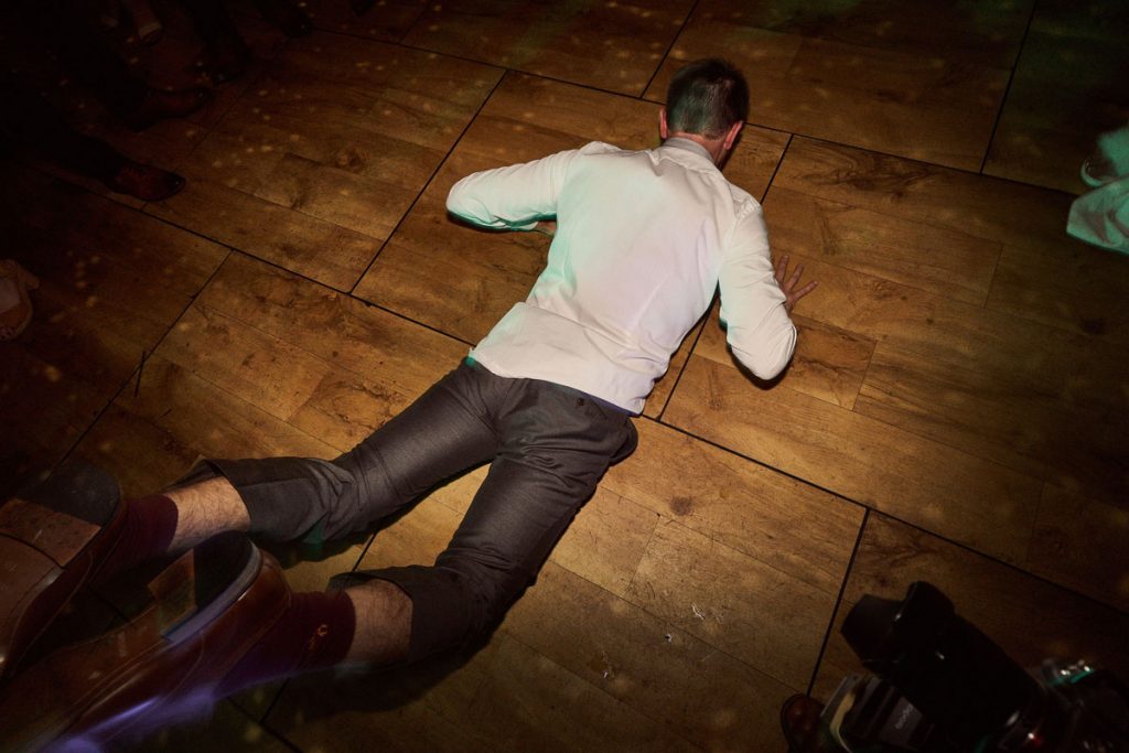 wedding guest doing the worm on dance floor
